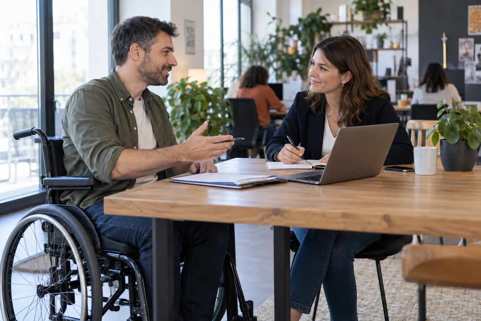 Un candidat en fauteuil roulant échange avec une conseillère emploi